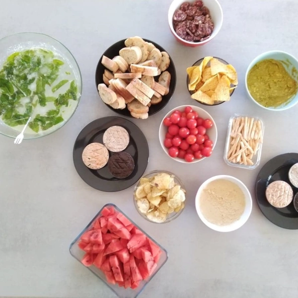 Des snacks variés entourent deux grands saladiers remplis de cocktails.