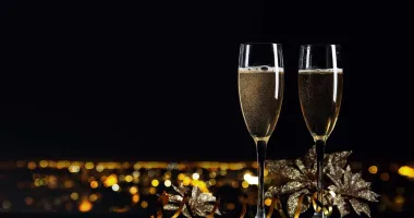 Flûte à champagne remplie d'un cocktail bicolore avec une base dorée pétillante surmontée d'une couche verte.