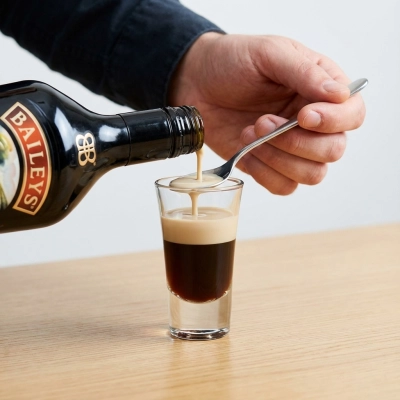 Ensuite, versez soigneusement Baileys, en utilisant le mur de verre à liqueur
