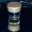 Un verre à shot sur un plateau, avec un cocktail en couches de couleurs marron et crème, appelé "dirty nipple".